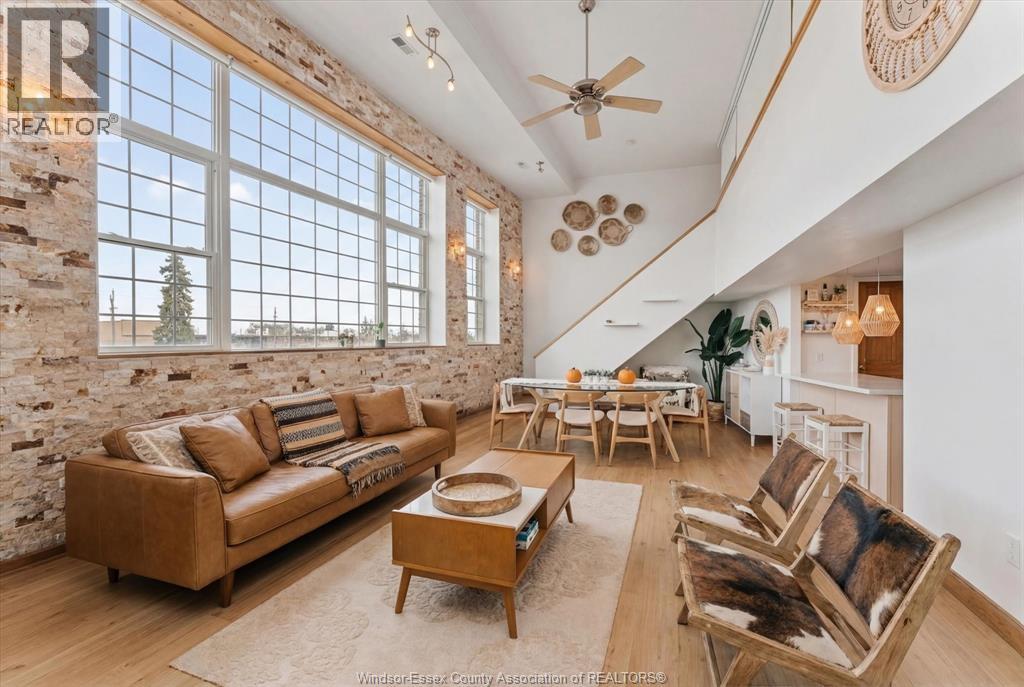 A living room with a couch, chairs, and a table.