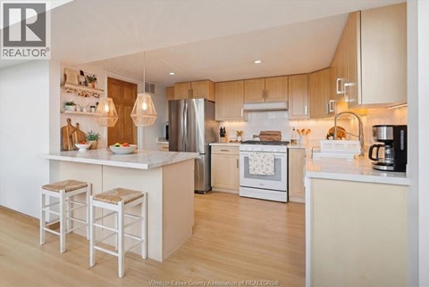 A kitchen with a white counter top and bar stools.