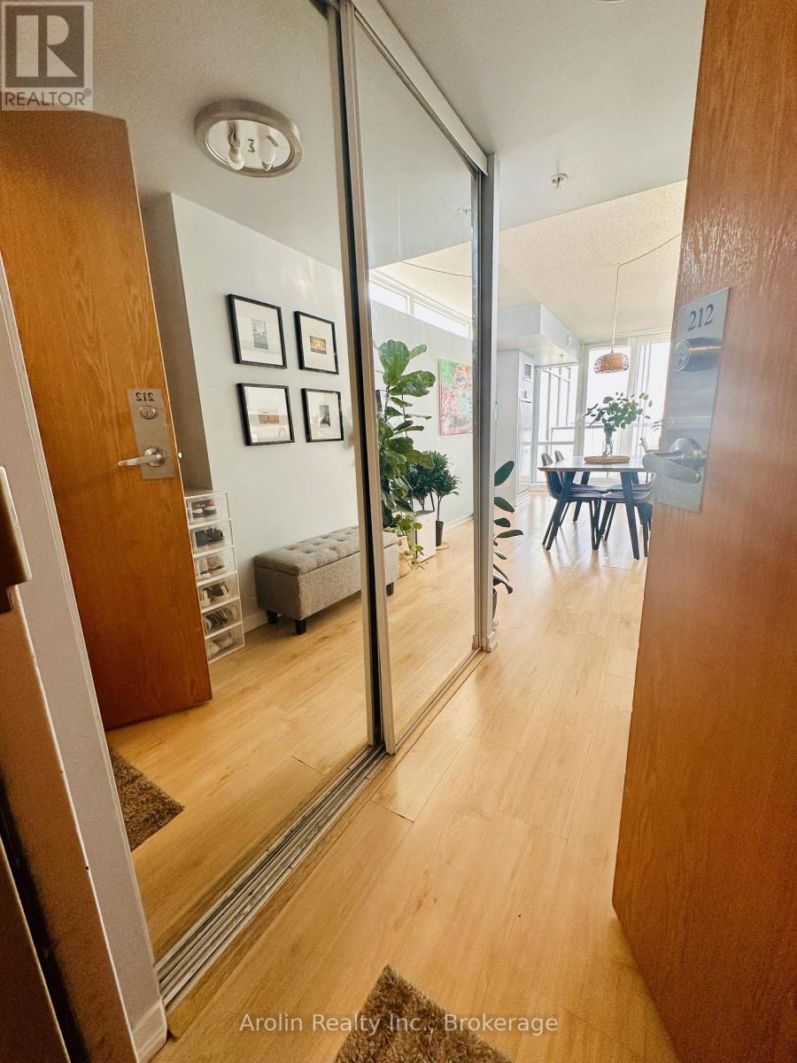 A hallway with a glass door leading to a dining room.