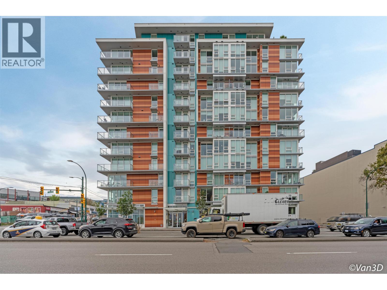 A tall residential building with cars parked in front.