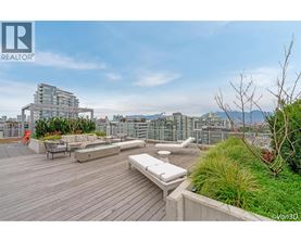 A rooftop patio with a bench and a table.
