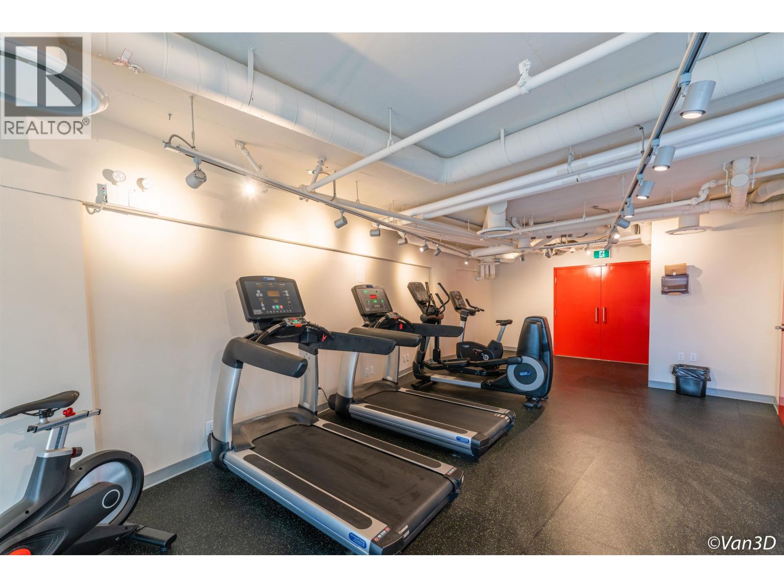 A gym with treadmills, exercise bikes, and a red door.