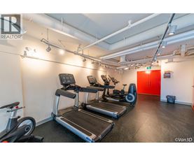 A gym with treadmills, exercise bikes, and a red door.