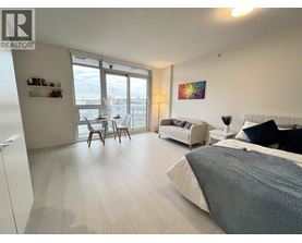 A bedroom with a large bed and a balcony with chairs.