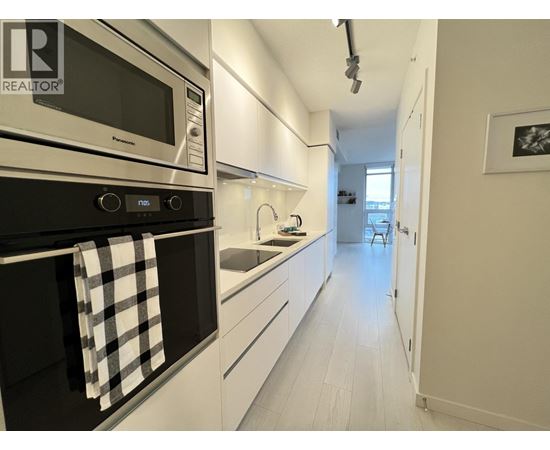 A modern kitchen with white cabinets and a black oven.