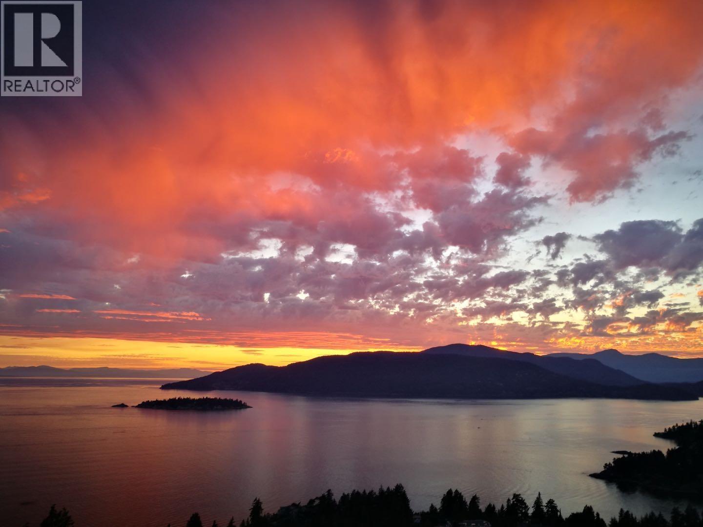 A beautiful sunset over a lake with a small island in the distance.