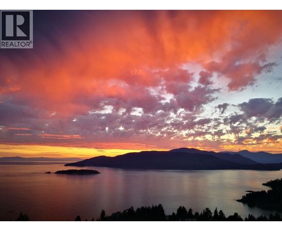 A beautiful sunset over a lake with a small island in the distance.