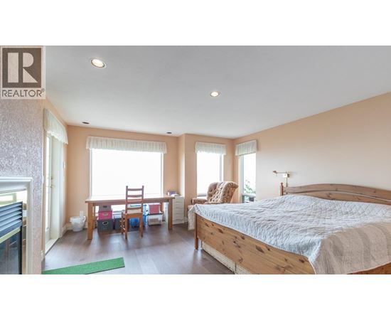 A bedroom with a large bed and a desk with a chair.