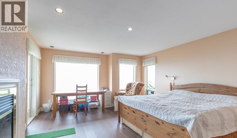 A bedroom with a large bed and a desk with a chair.