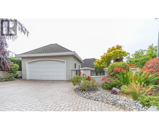 A house with a driveway and a garden in front.