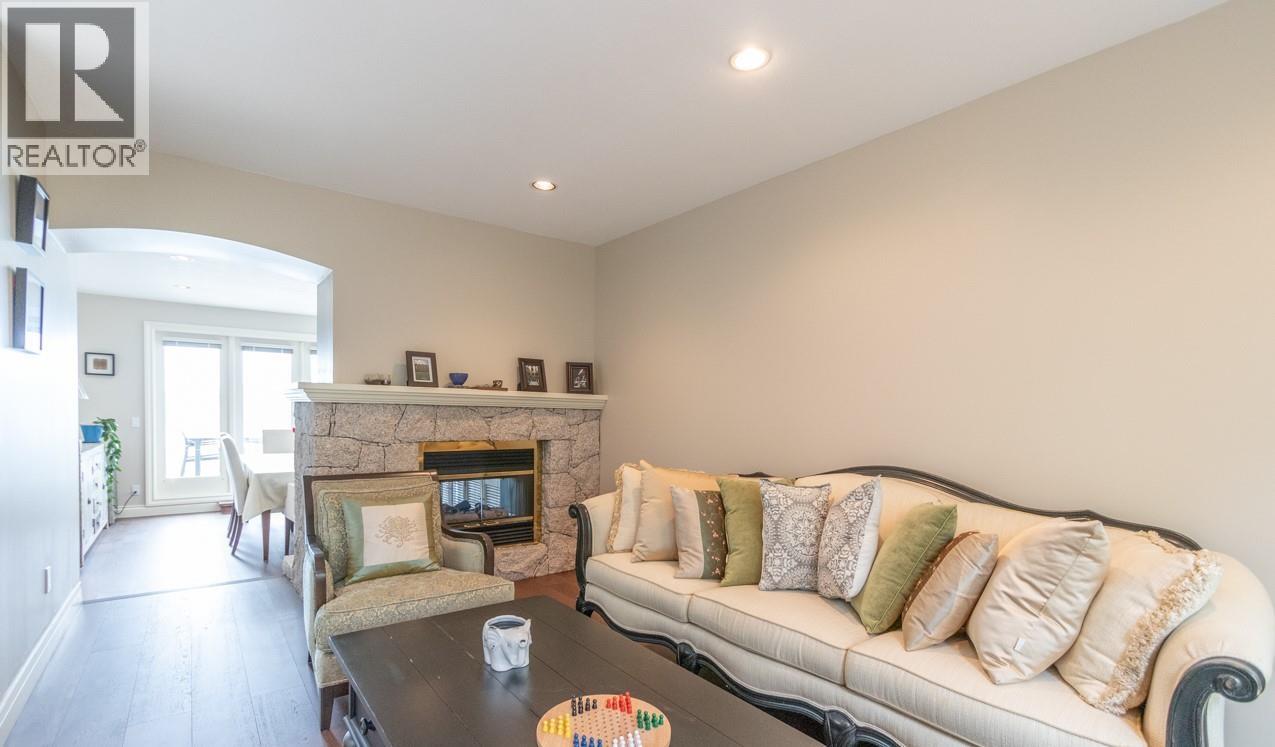 A living room with a couch, coffee table, and fireplace.
