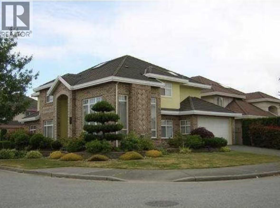 A house with a brown roof and a tree in front.
