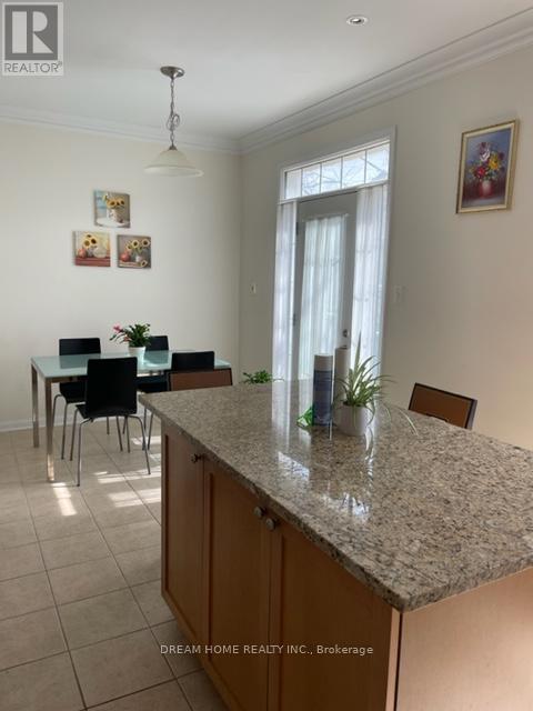 A kitchen with a granite countertop and a dining table with chairs.