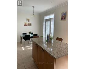 A kitchen with a granite countertop and a dining table with chairs.
