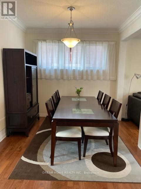 A dining room with a wooden table and chairs.