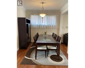 A dining room with a wooden table and chairs.