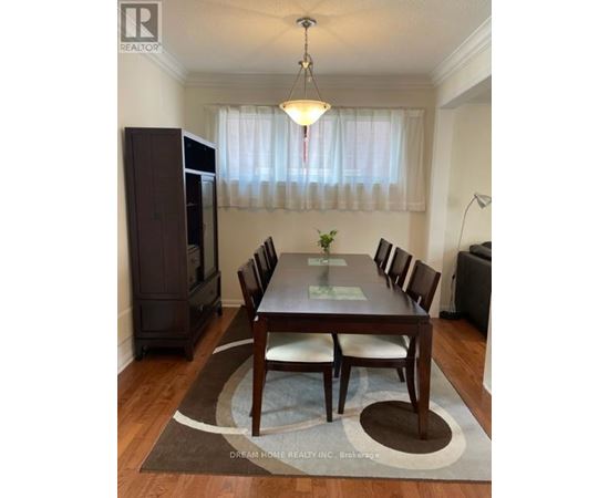 A dining room with a wooden table and chairs.
