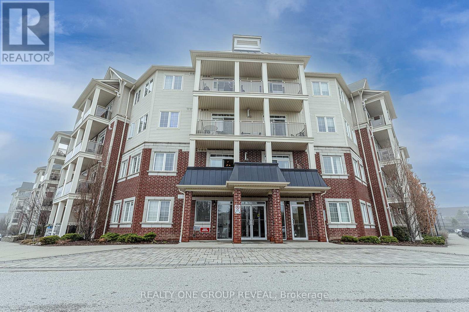 A large apartment building with a red brick facade and multiple balconies.