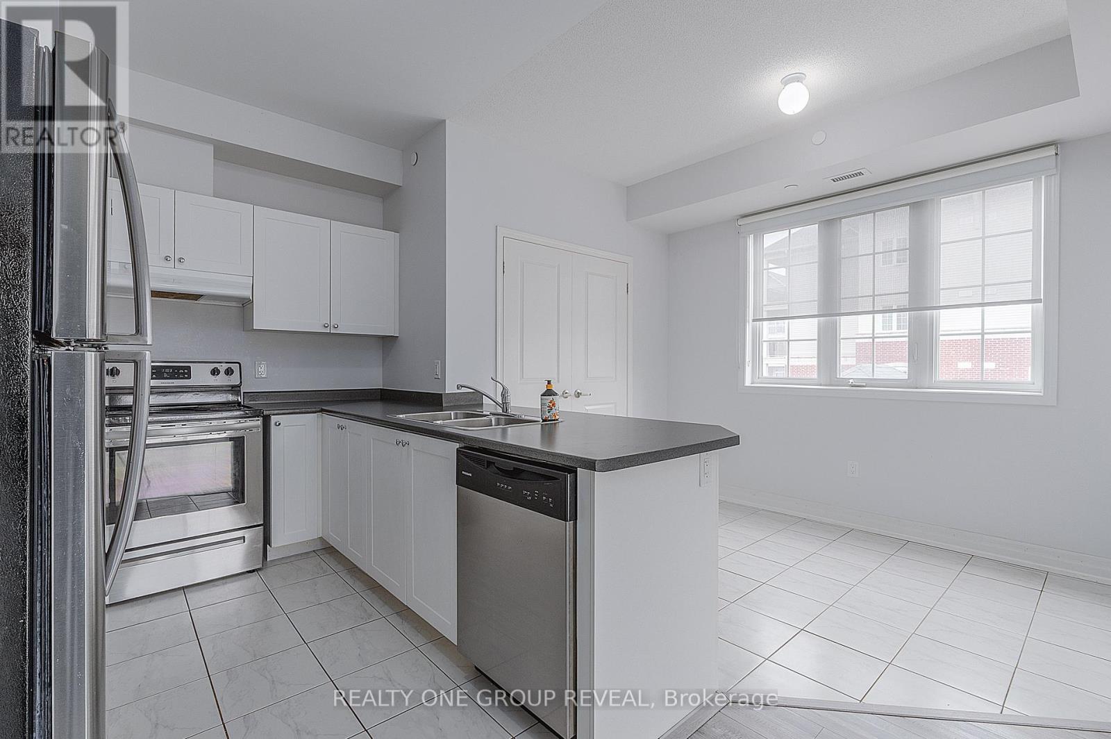 A modern kitchen with white cabinets and stainless steel appliances.