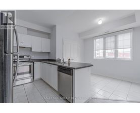 A modern kitchen with white cabinets and stainless steel appliances.