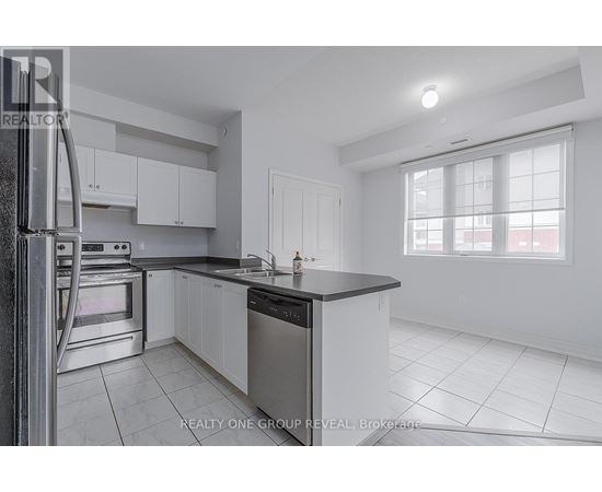 A modern kitchen with white cabinets and stainless steel appliances.
