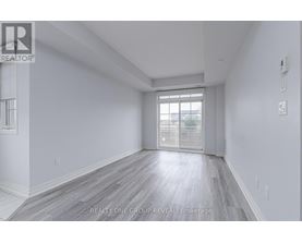 A spacious room with a window and wooden flooring.