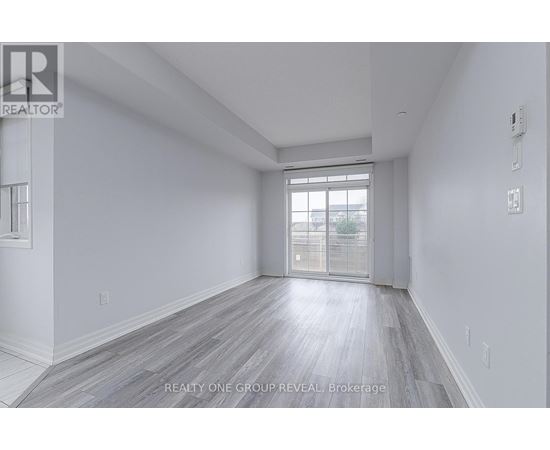 A spacious room with a window and wooden flooring.