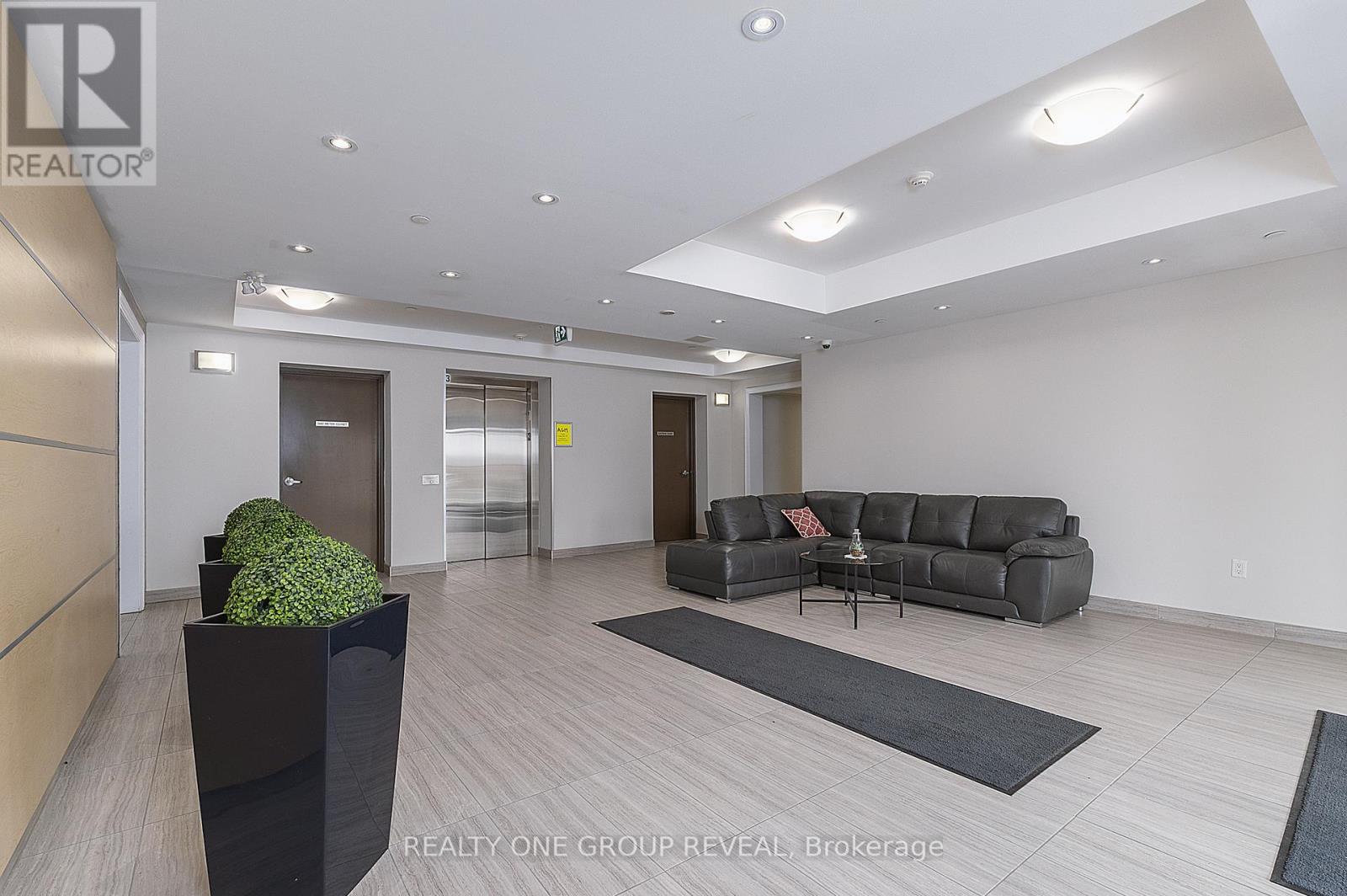 A modern living room with a grey sofa and a black planter.