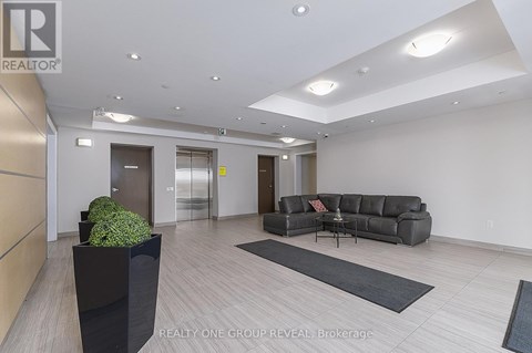 A modern living room with a grey sofa and a black planter.