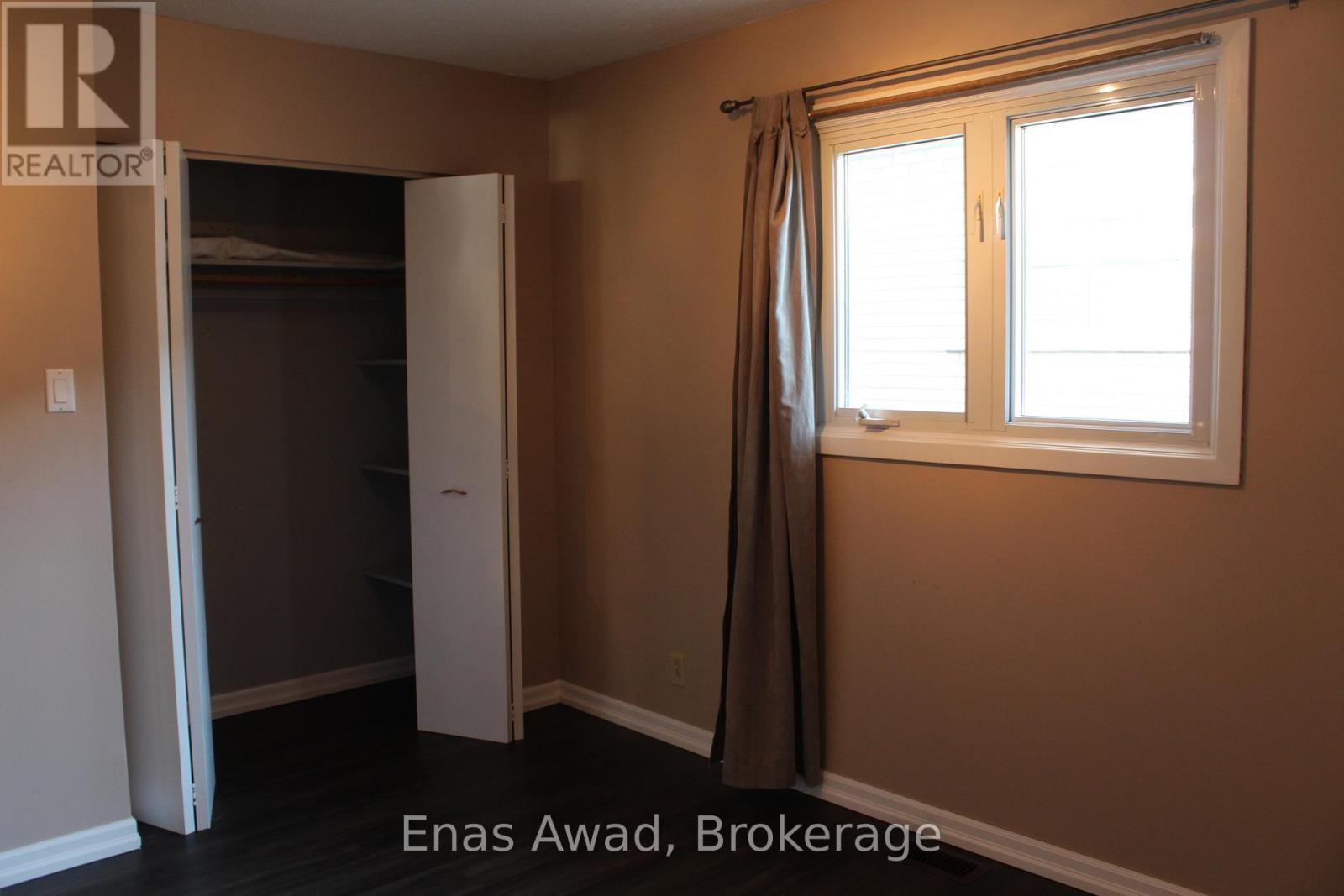 A bedroom with a window and a closet.