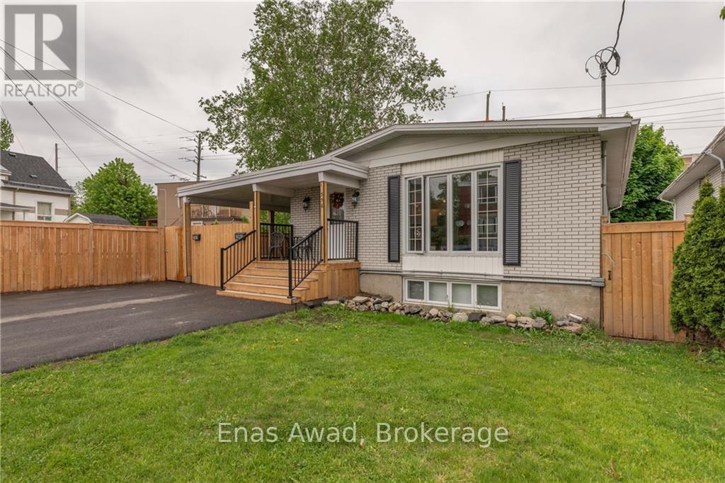 A house with a grey roof and a wooden fence in the front yard.
