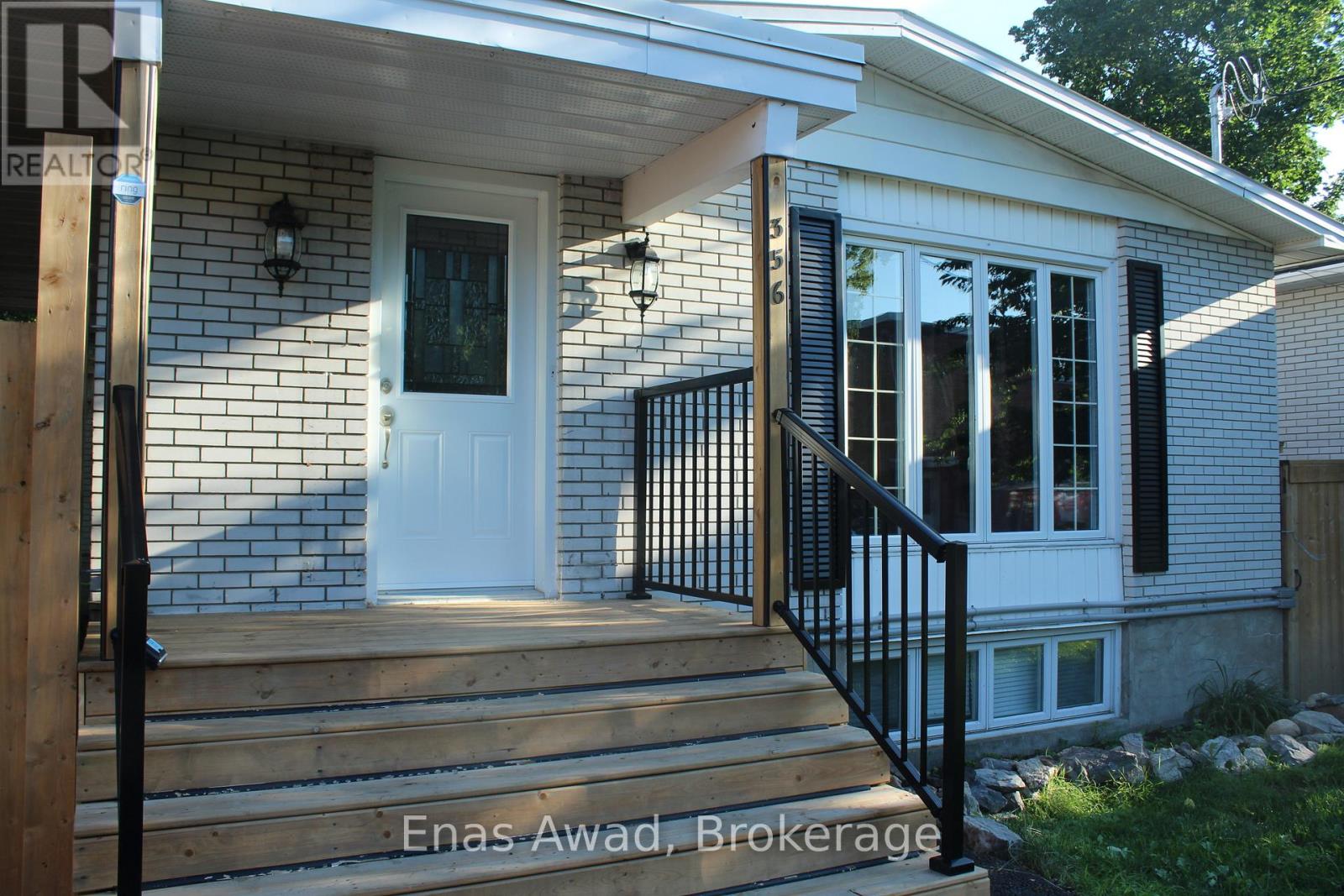 A house with a white door and black railings.