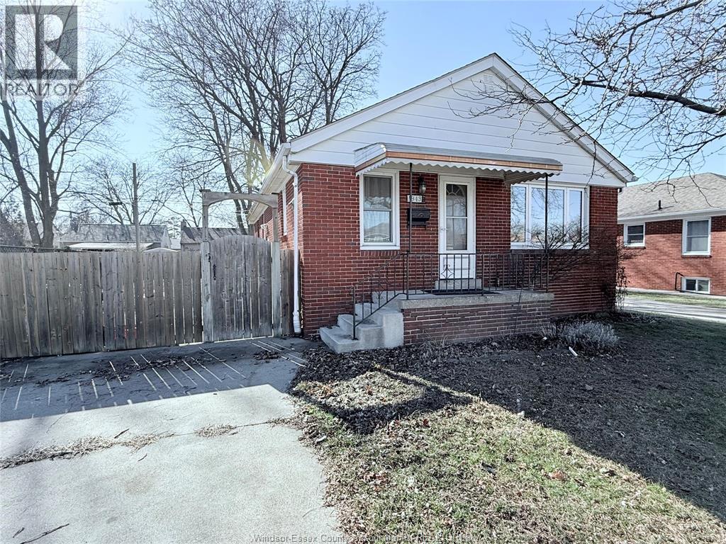 A red brick house with a white roof and a wooden fence.