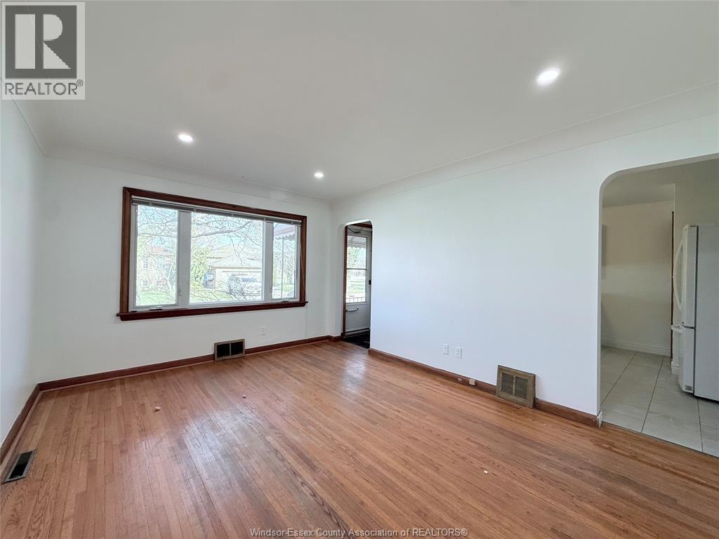 A room with wooden flooring and a large window.