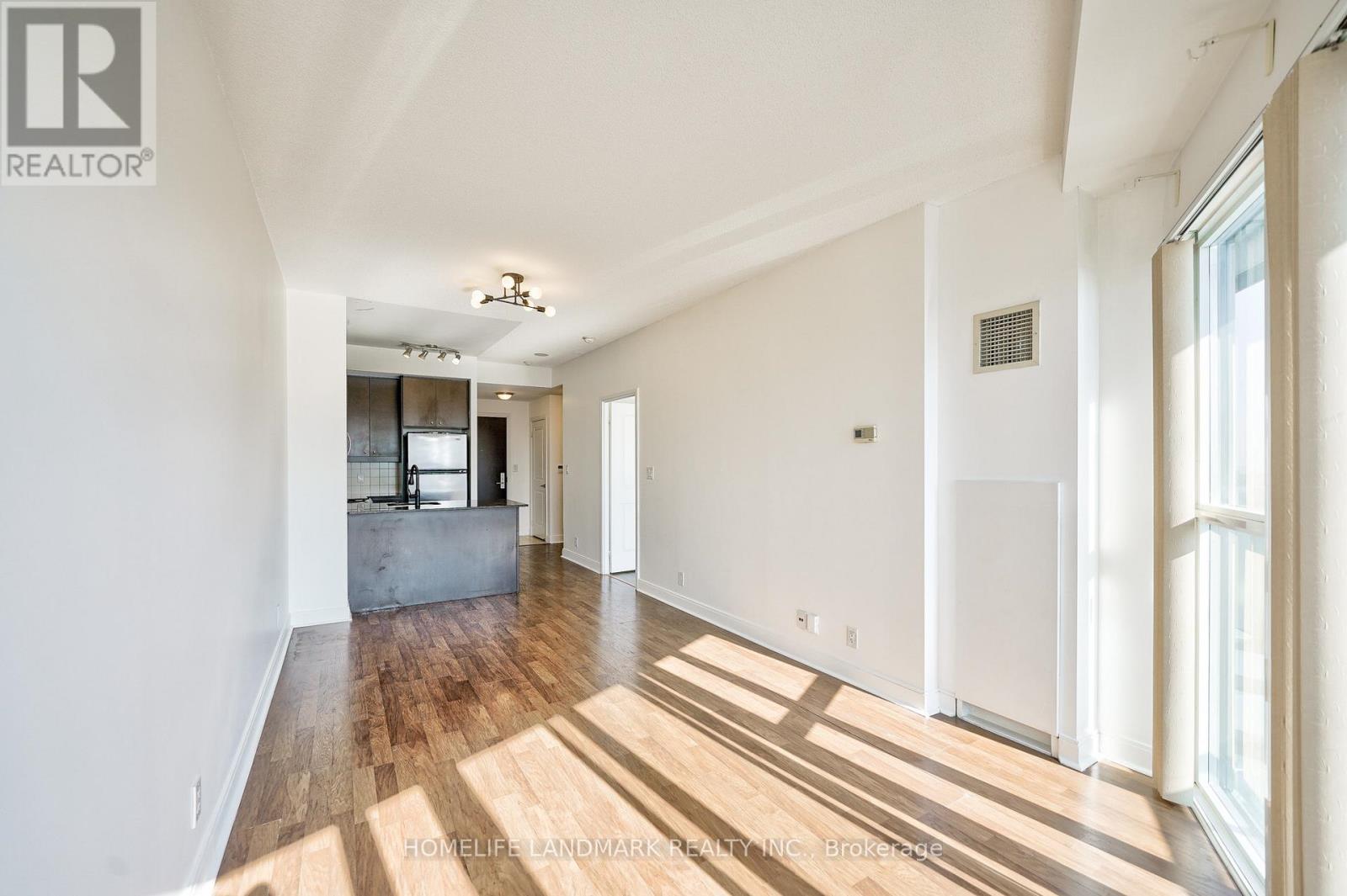A spacious room with wooden floors and white walls.