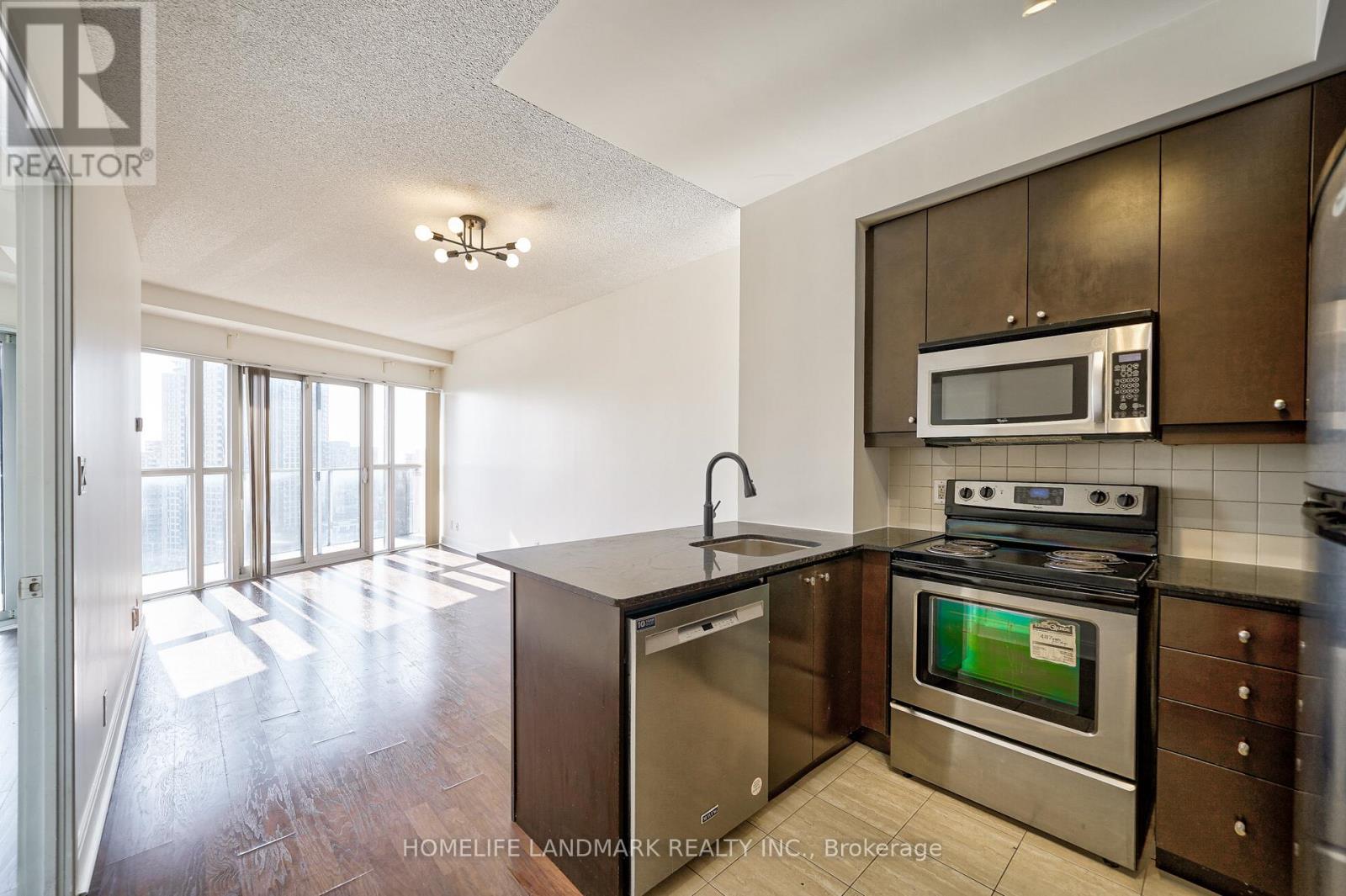 A modern kitchen with stainless steel appliances and wooden cabinets.