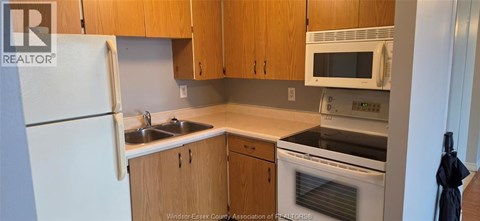 A kitchen with wooden cabinets and a white refrigerator.
