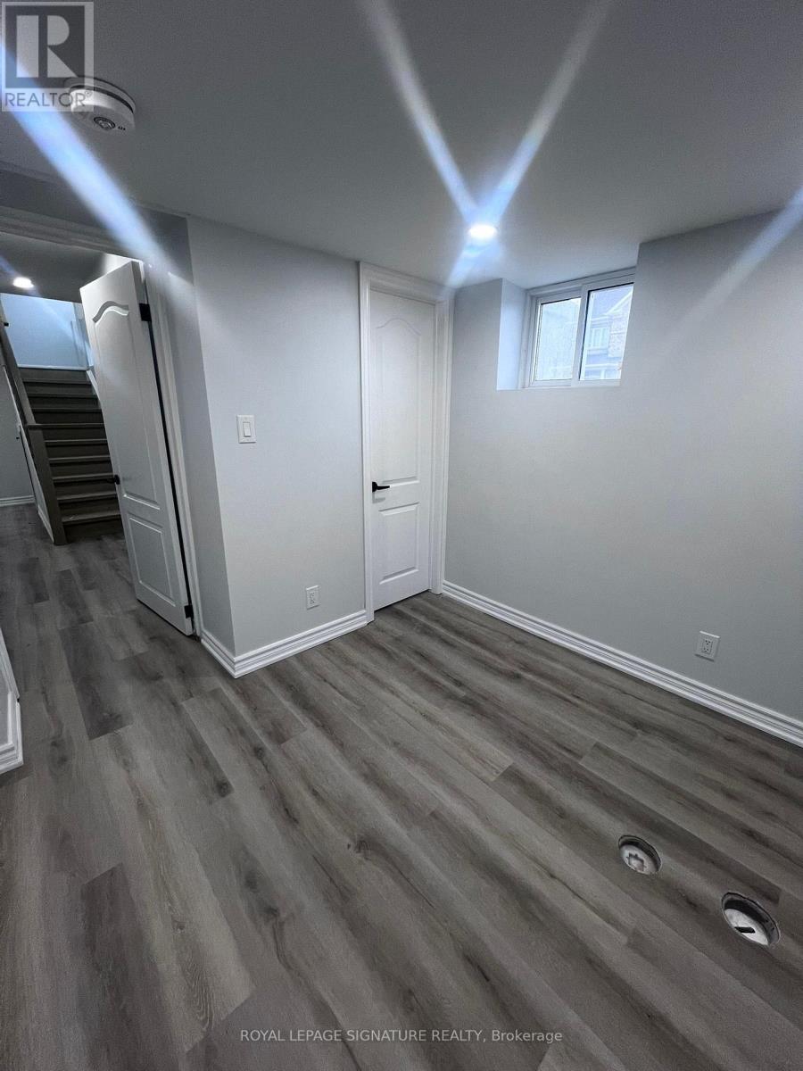 A room with a wooden floor and a staircase.