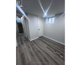 A room with a wooden floor and a staircase.
