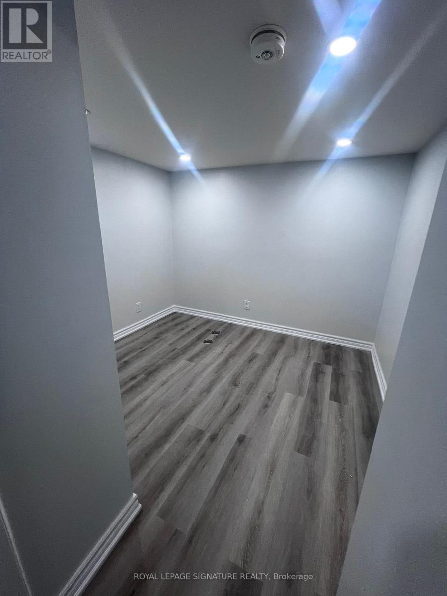 A room with wooden flooring and white walls.