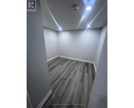 A room with wooden flooring and white walls.