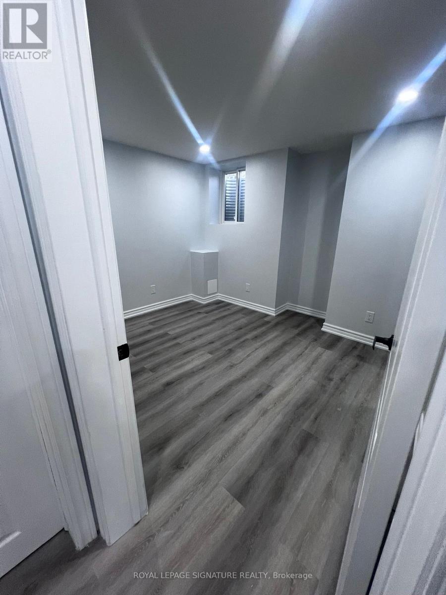A room with wooden flooring and white walls.