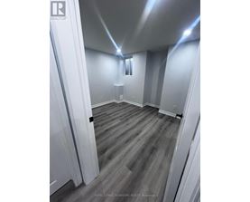 A room with wooden flooring and white walls.