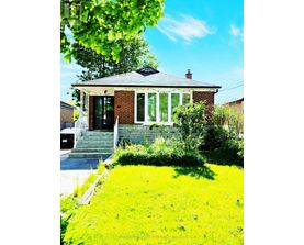 A small house with a green lawn in front.
