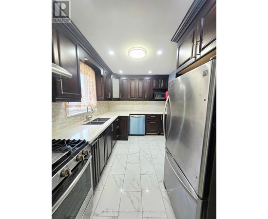 A kitchen with a stove top oven and a refrigerator.