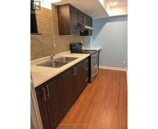 A kitchen with wooden cabinets and a white counter top.