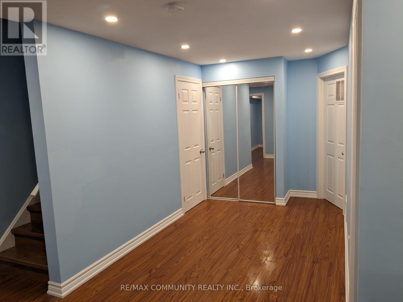 A hallway with white doors and wooden floors.