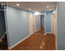 A hallway with white doors and wooden floors.