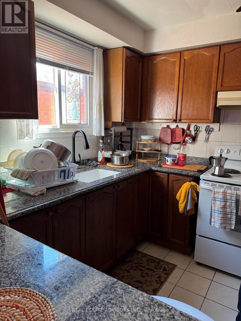A kitchen with brown cabinets and a granite counter top.