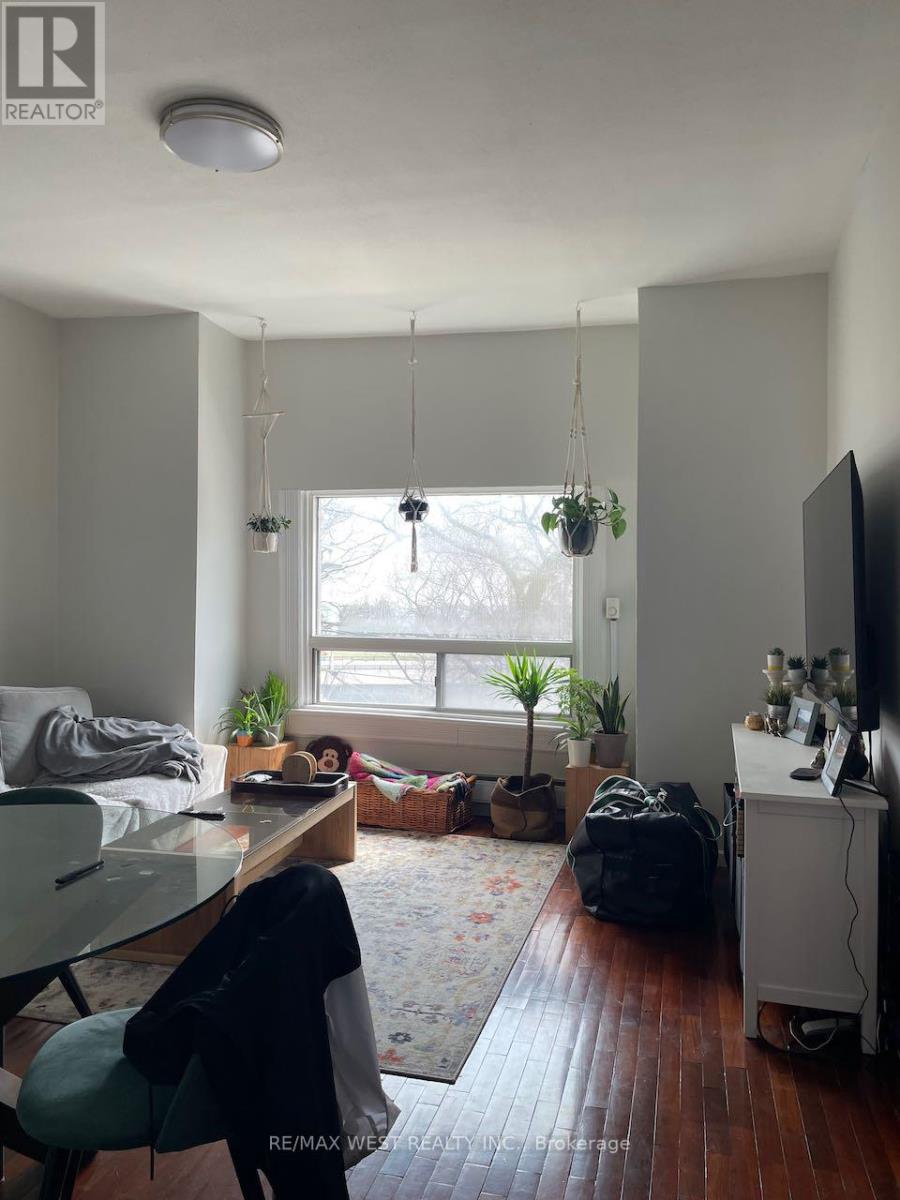 A living room with a wooden floor and a large window.